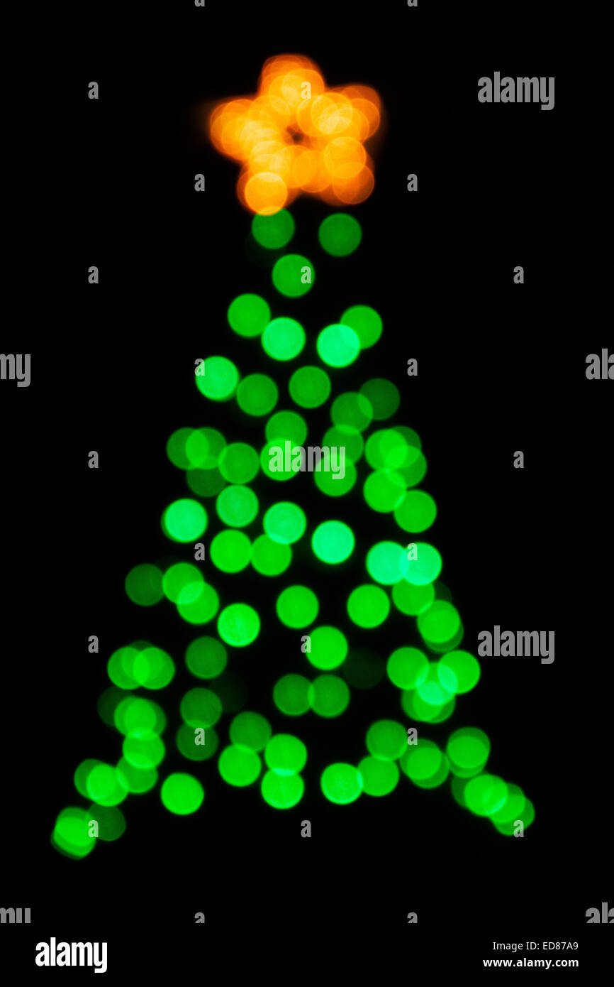 Christmas tree blurry green lights and yellow star, black background, avante garde, surreal, abstract impression Stock Photo