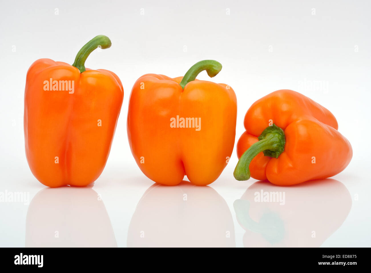 tree orange peppers in a row isolated on white background Stock Photo