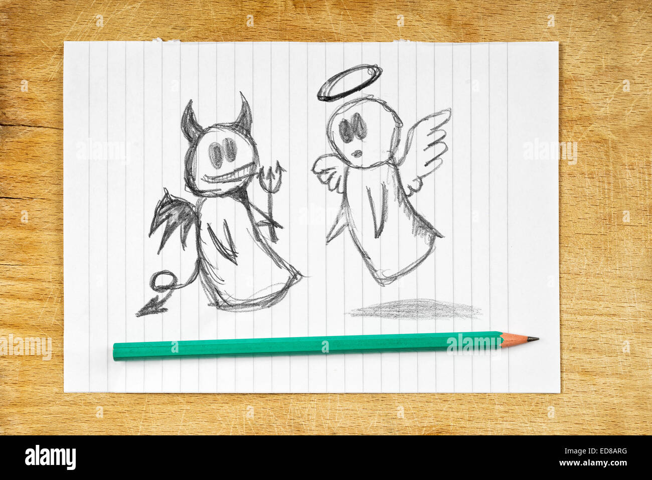 Doodle drawing of angel and devil on white paper as concept of conscience and moral dilemma in fight of good and evil. Stock Photo