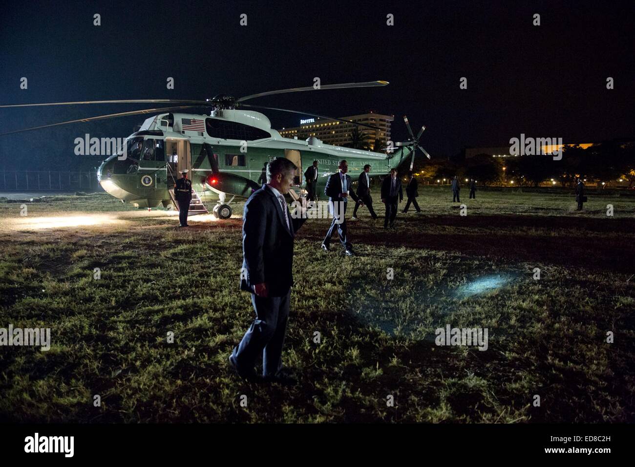 A US Secret Service agent shines a flashlight for the President Barack Obama as he walked to the motorcade from Marine One upon arrival at the Florento landing zone April 28, 2014 in Manila, the Philippines. Stock Photo