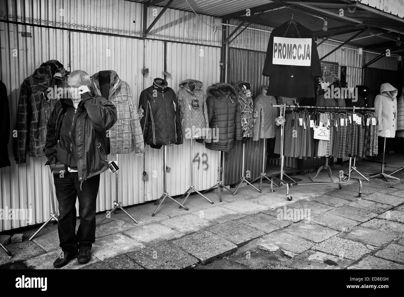 Sales person at Rozycki Bazaar in front of his merchandise Stock Photo