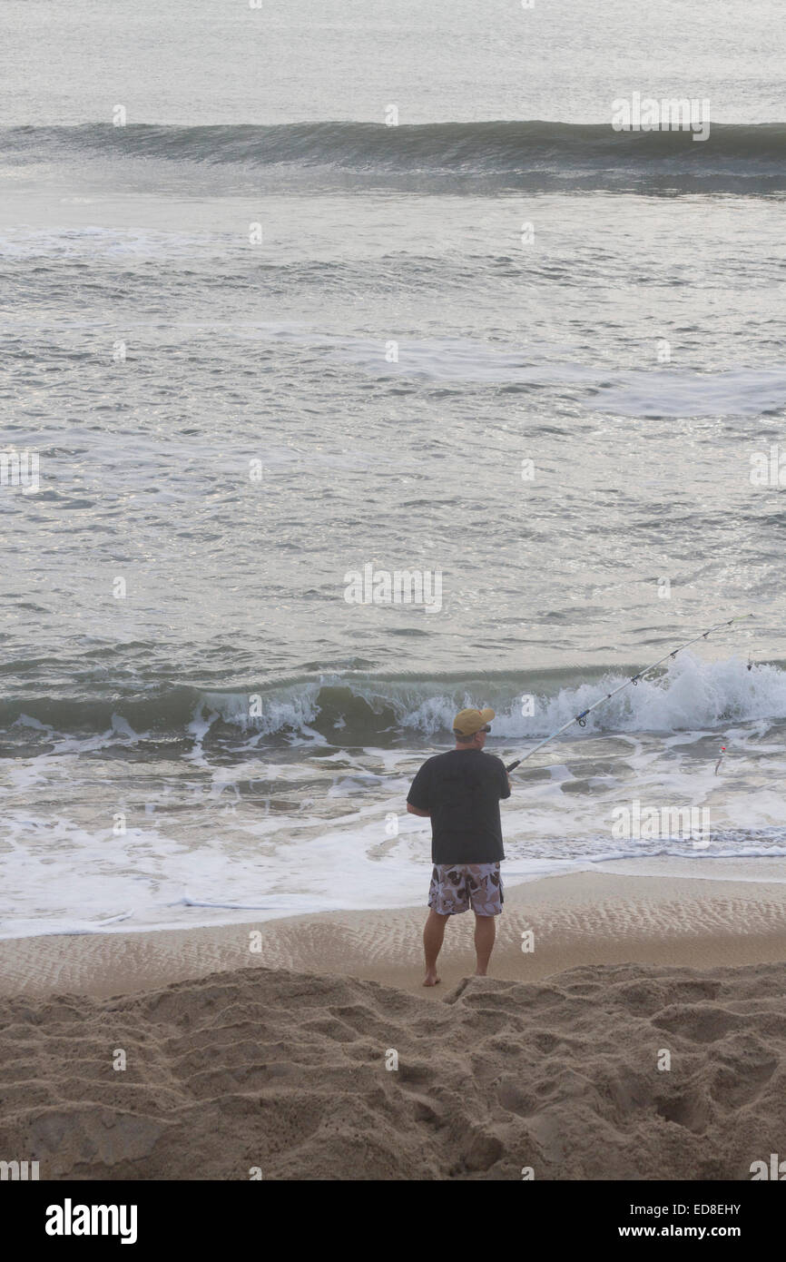 Cape Hatteras, Outer Banks, North Carolina, USA - October 18, 2013:  A man casts a fishing line into the sea from the beach Stock Photo