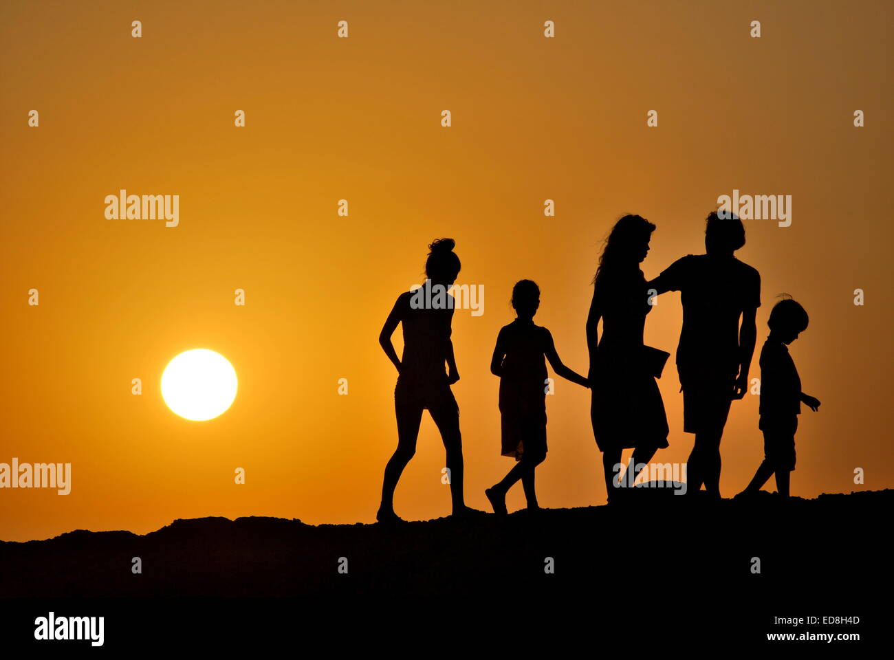 backlight of a 5 member family at sunset Stock Photo