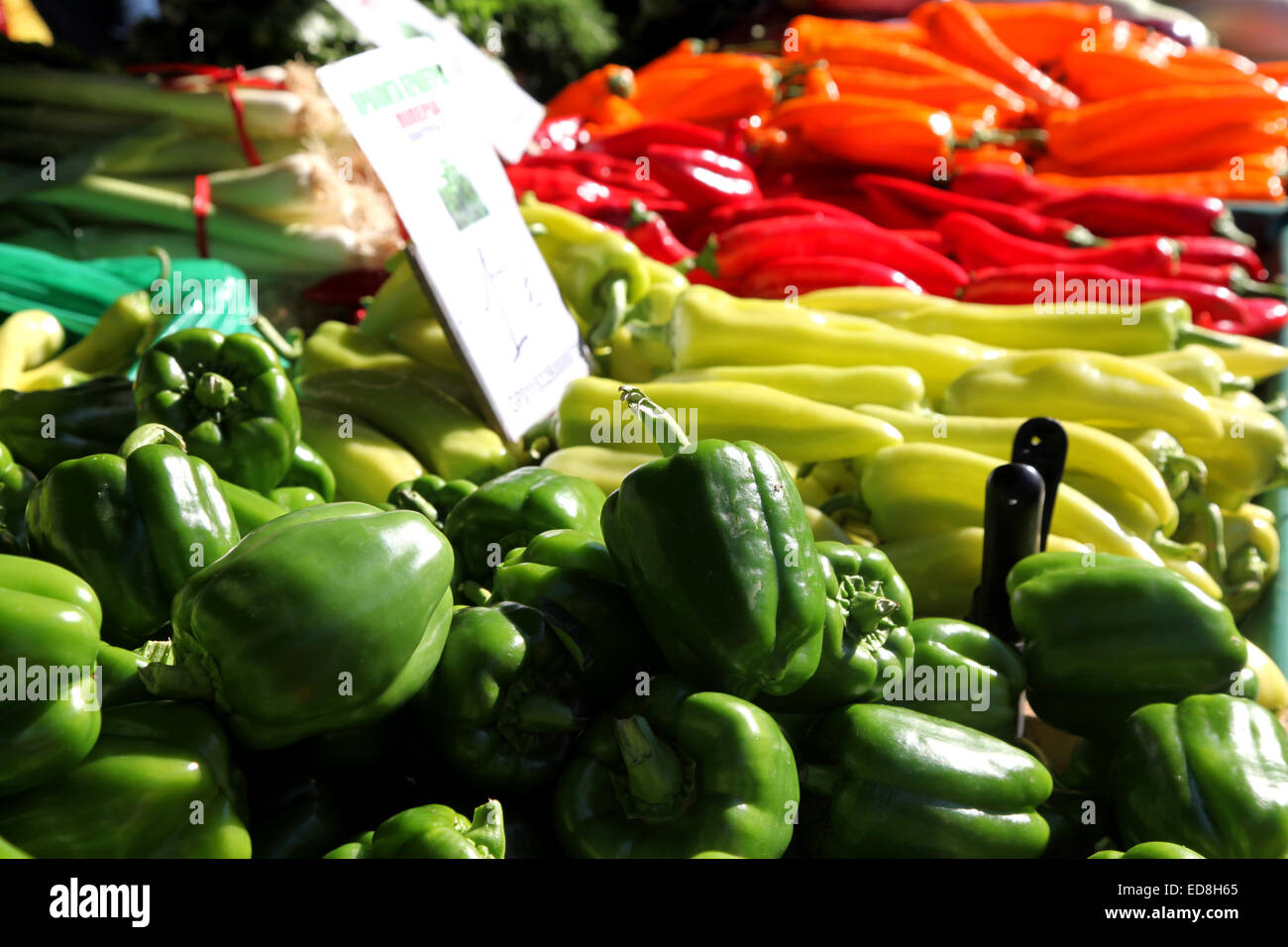 Bright, colourful vegetables on a Market stall in Crete, orange, red, lime green and dark green sweet peppers look delicious Stock Photo