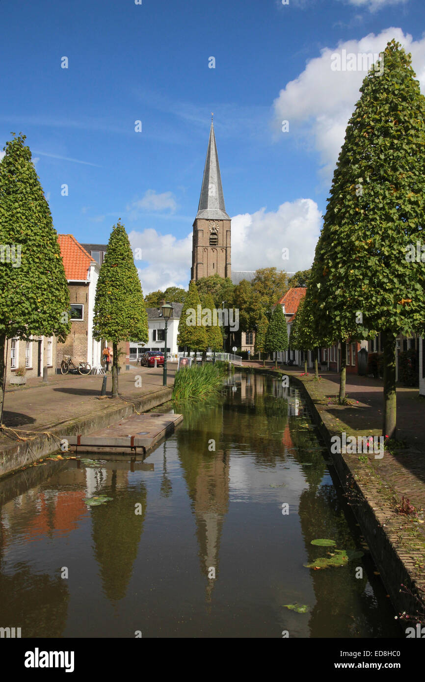 View along a canal in Maasland towards the Oude Kerk. Stock Photo