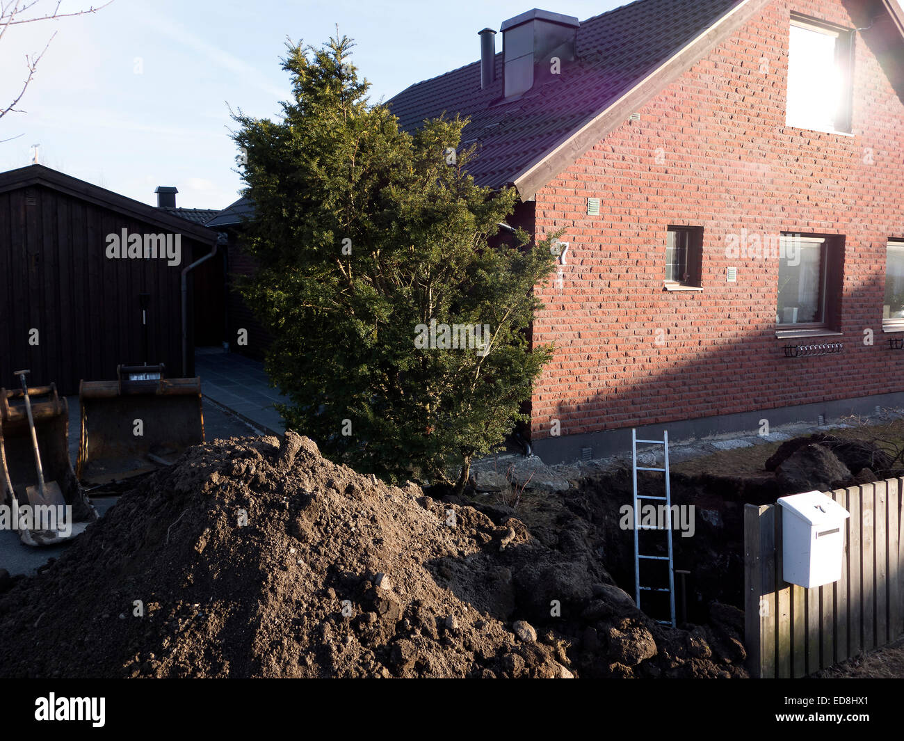 Water Line Repair. The pit  is dug for repair of a damaged main water line pipe in the garden of a cottage. Stock Photo