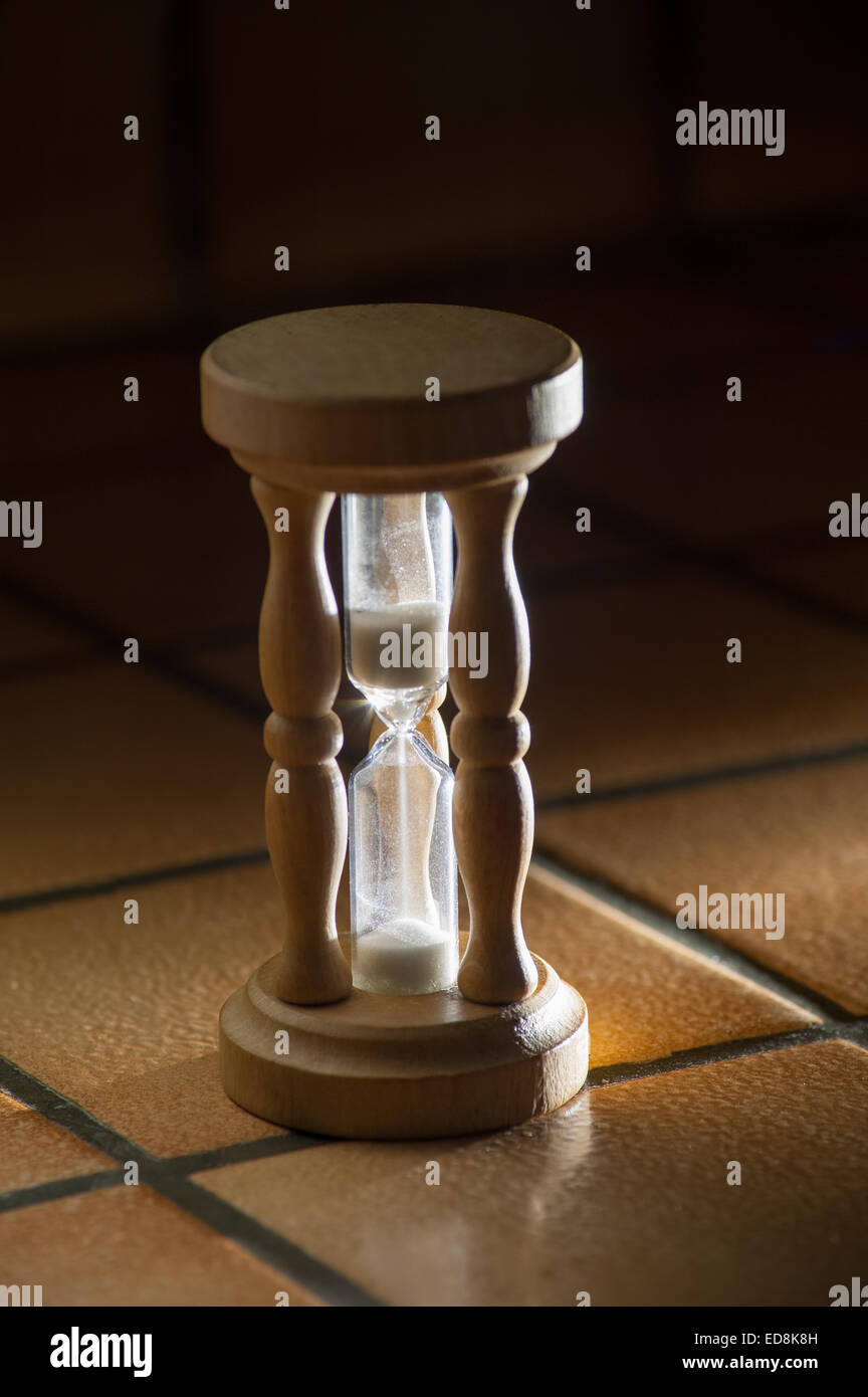 timer hourglass streaming grains of sand flowing through depicting things are running out Stock Photo