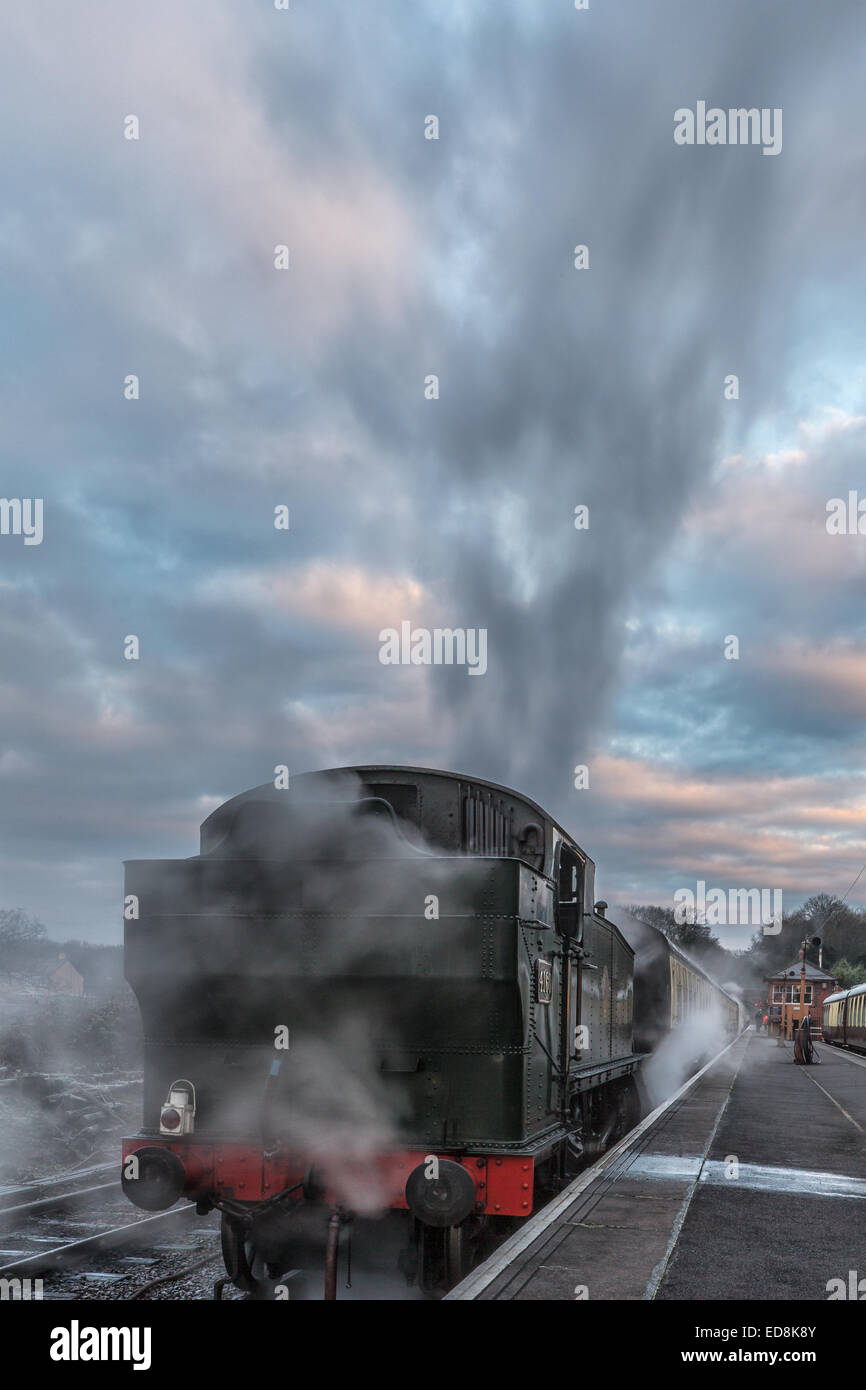 A frosty morning and GWR Large Pairie 4160 is steaming up and supplying heating steam to the carriages of the first train of the Stock Photo