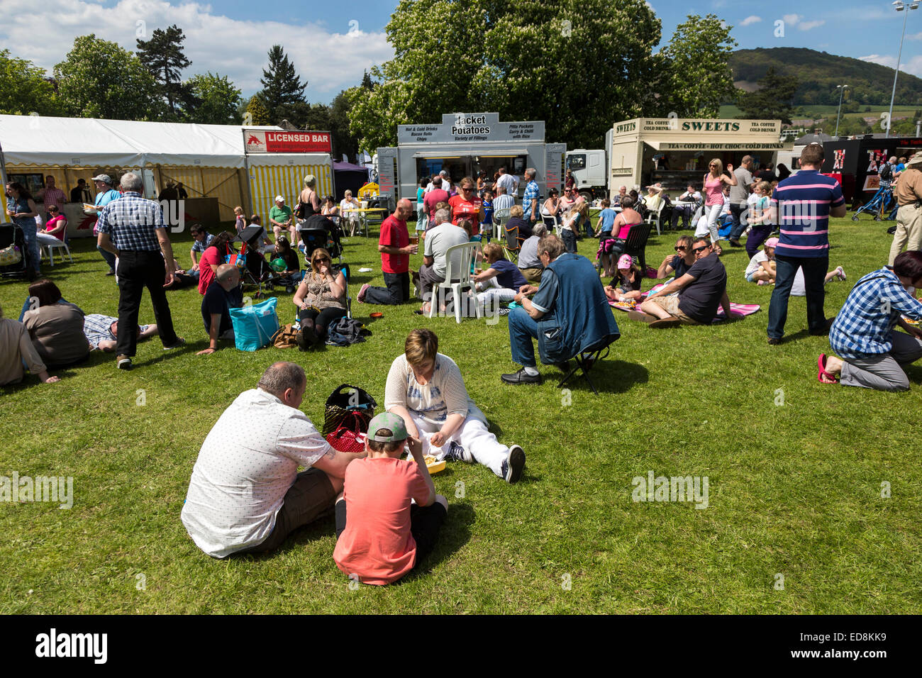 People sitting on grass eating fast food at the Steam Rally