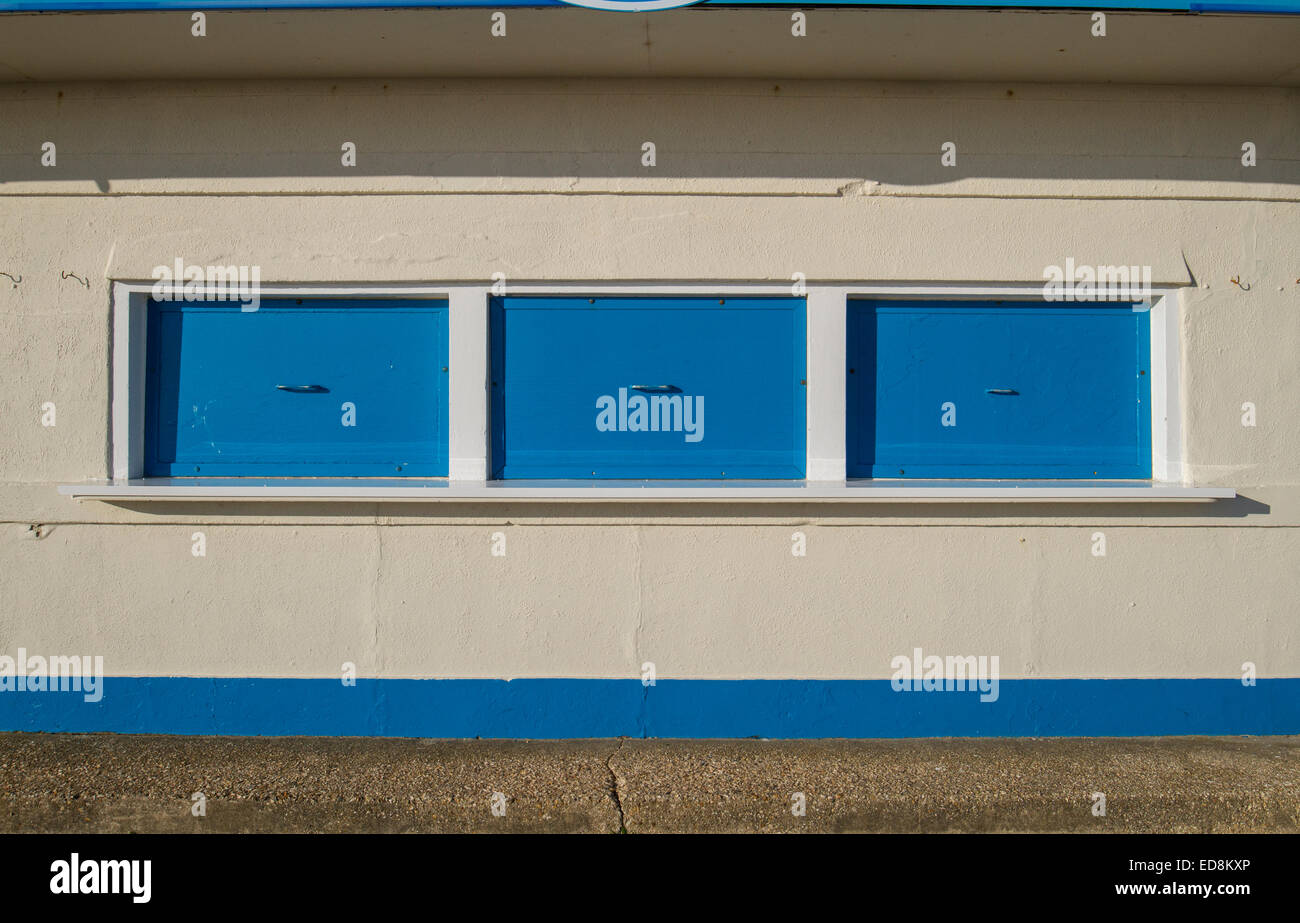 closed blue shutters on kiosk on cream building Stock Photo