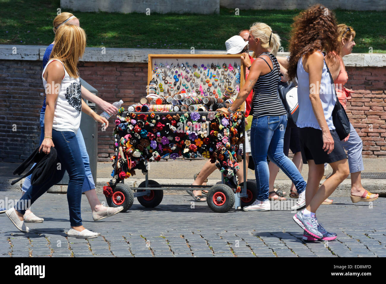 A blond woman pushing a small trolley loaded with colourful Italian ...