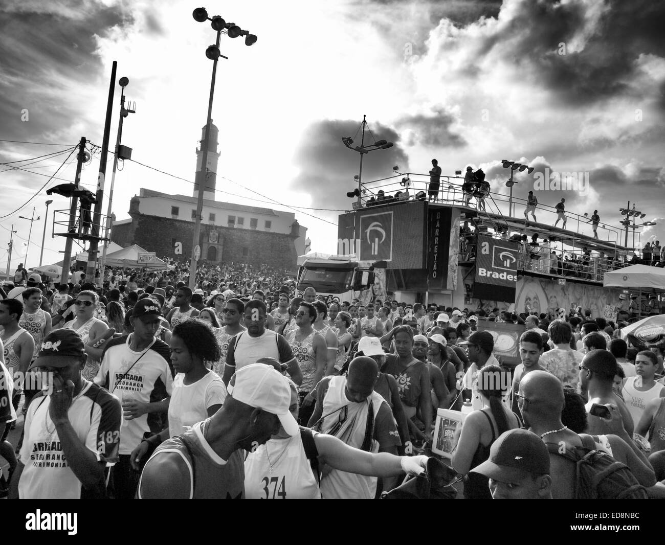 SALVADOR, BRAZIL - MARCH 3, 2014: Crowds of Brazilians celebrate carnival alongside a trio electrico music truck in Barra. Stock Photo