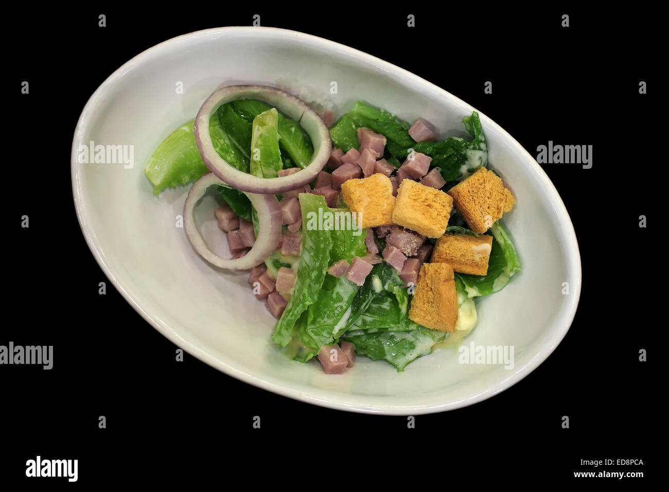 delicious caesar salad with ham on black background Stock Photo