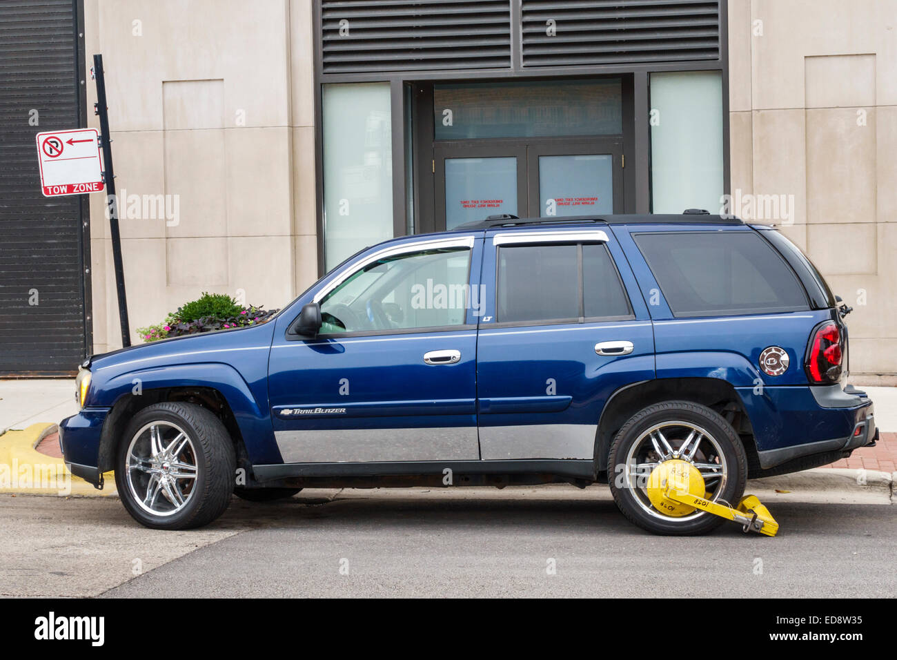 Chicago Illinois,Gold Coast Historic District,neighborhood,SUV,vehicle,Trail Blazer,blue,parked,illegal parking,sign,wheel clamp,boot,enforcement,IL14 Stock Photo