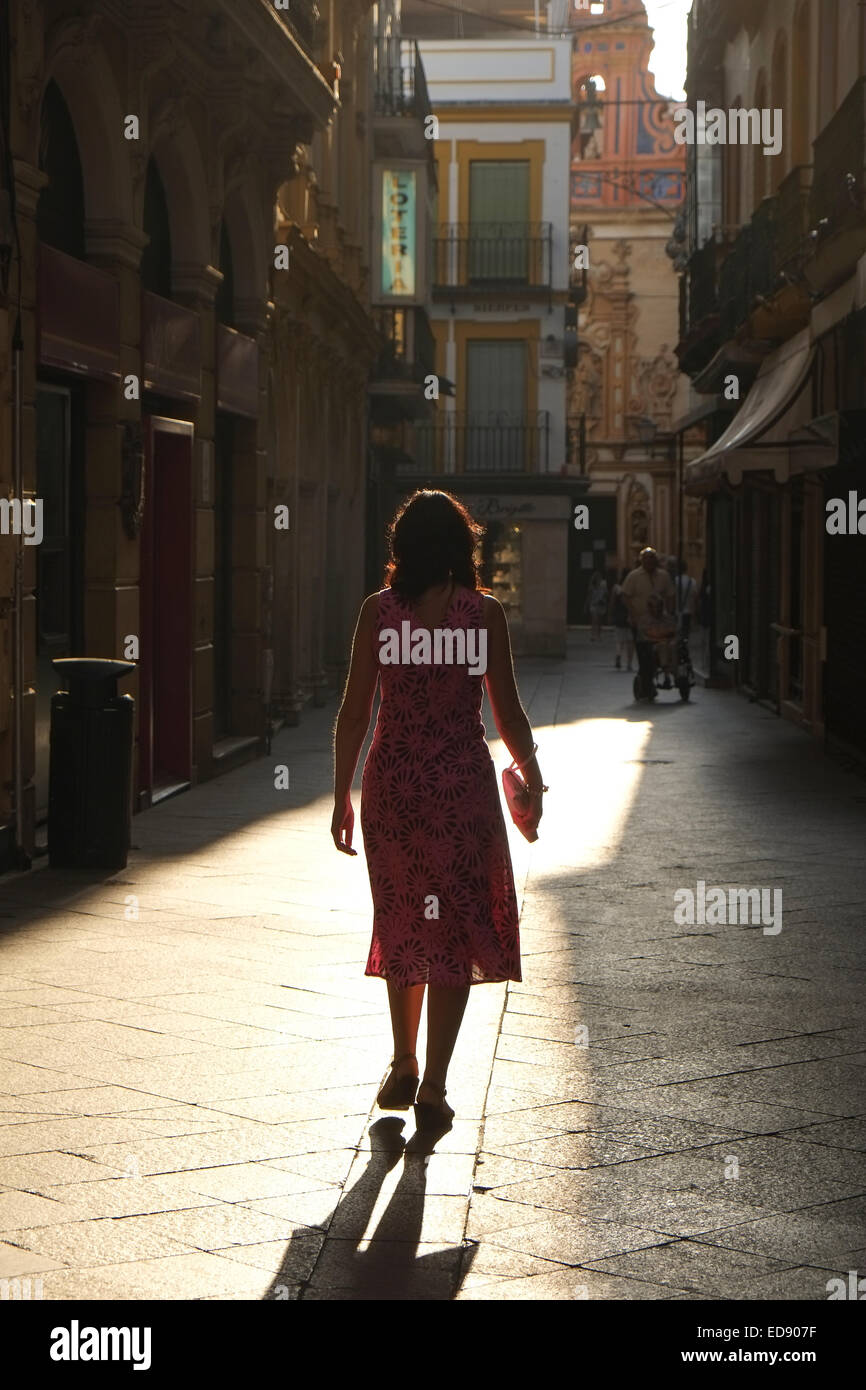 Seville Spain: Women walking along sunlit street in Seville Spain Stock Photo