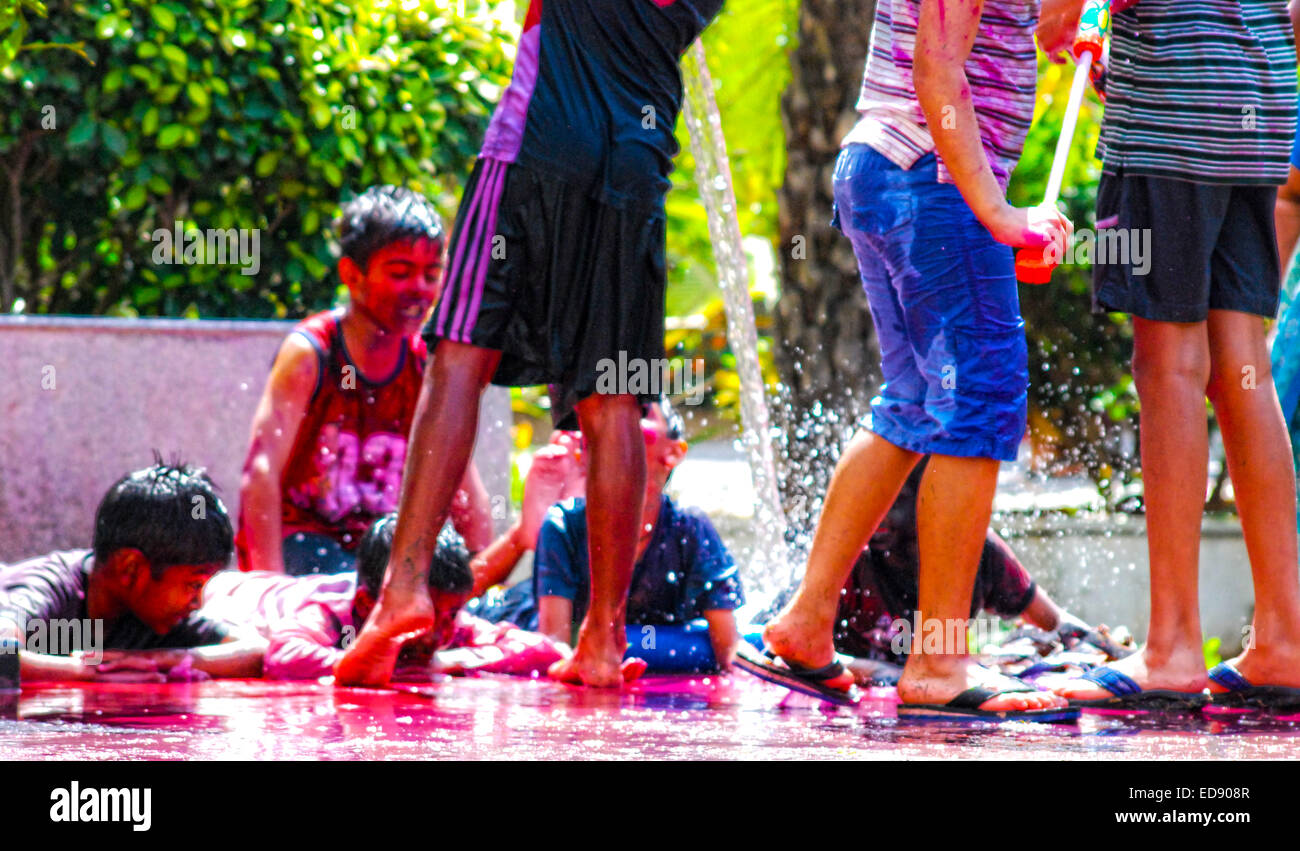 Group of young boys playing with powder colors & water during the spring hindu festival Holi also known as a festival of colors. Stock Photo