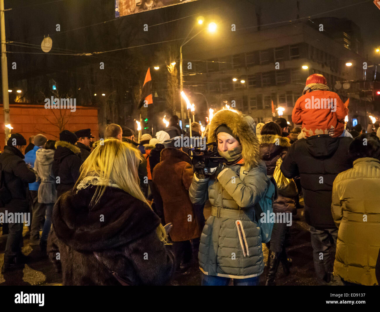 Journalists  LifeNews reporting during the torchlight procession. - Police detained a suspect in the attack on journalists during a torch procession January 1, 2015 in Kiev, Ukraine, in honor of the 106th anniversary of the birth of the conductor OUN Stepan Bandera. The collision damaged the camera operator, while the journalist's mobile phone. The assailant was charged with obstruction of the lawful professional activities of journalists and robbery. Stock Photo