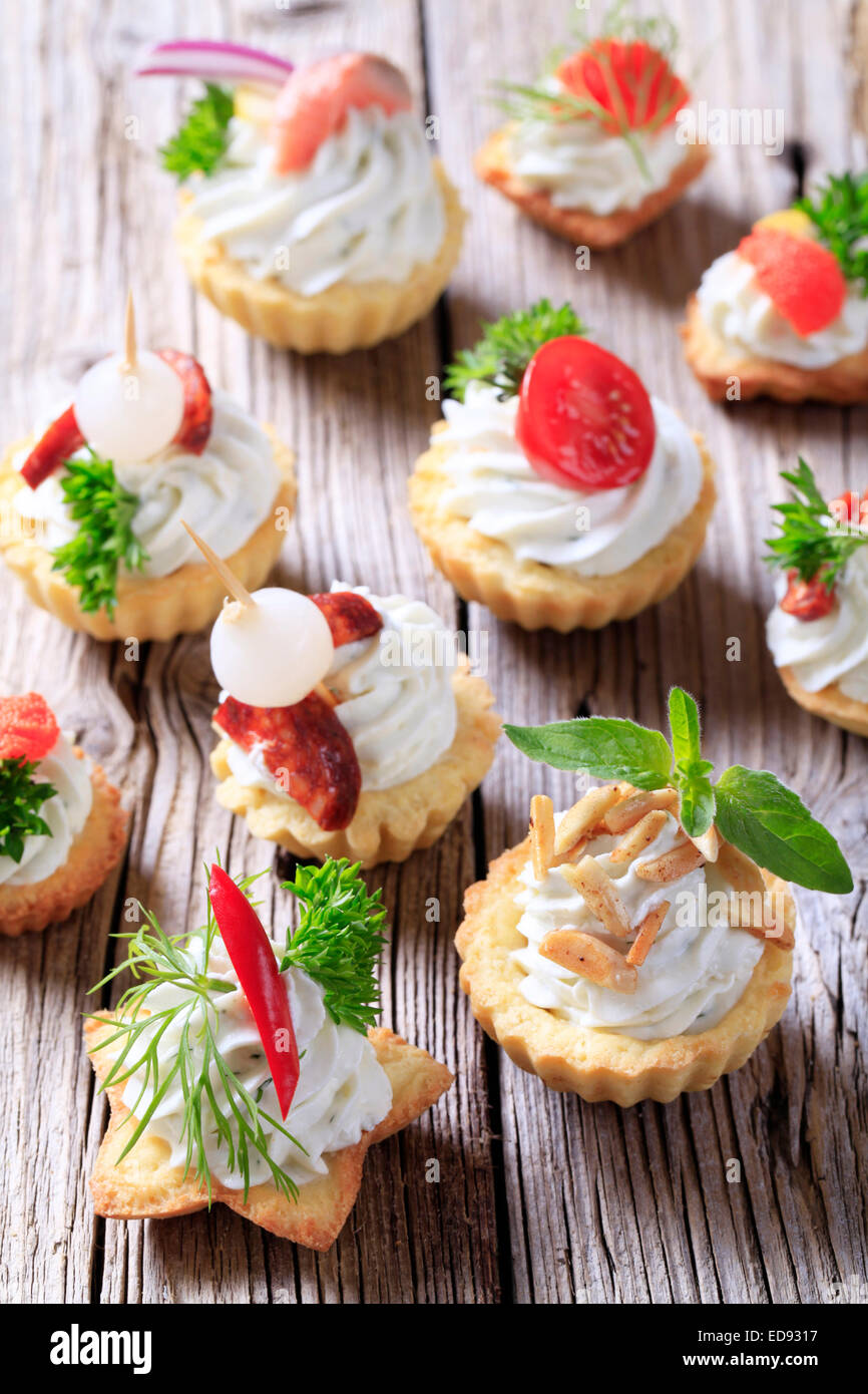 Tartlet pastry shells with cheese spread and garnish Stock Photo Alamy