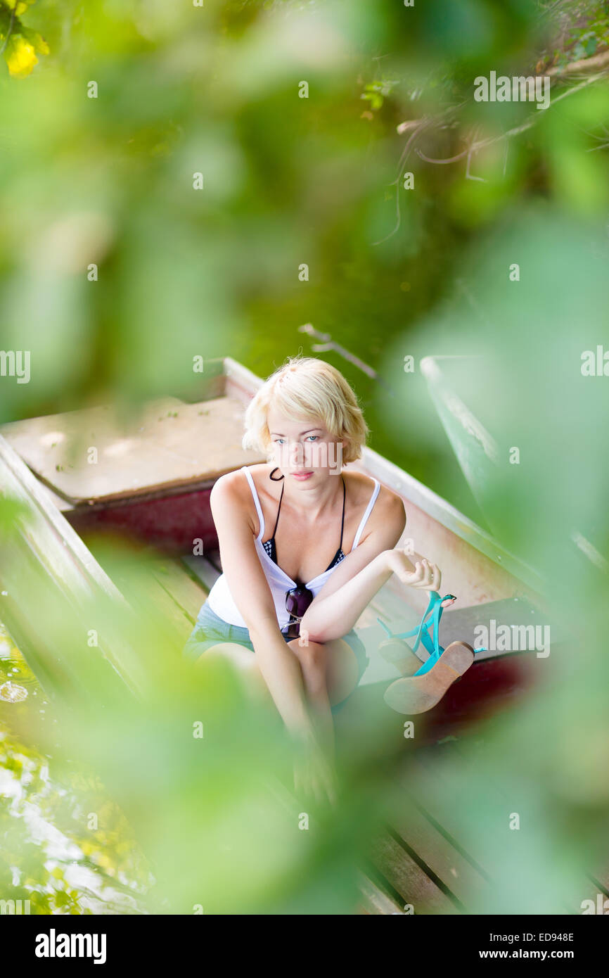 Woman relaxing on the vintage wooden boat. Stock Photo