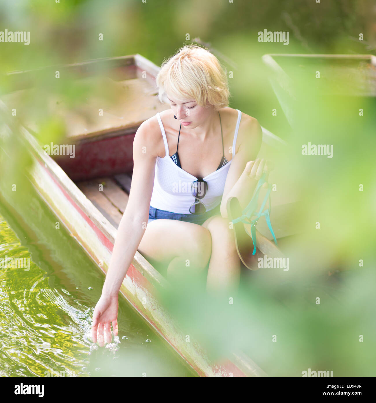 Woman relaxing on the vintage wooden boat. Stock Photo