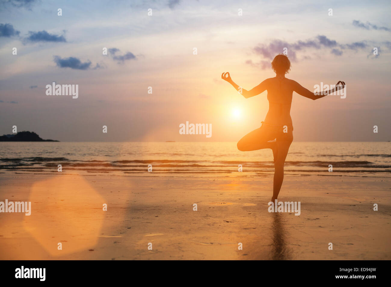 Silhouette of woman meditating on the sea beach. Yoga Stock Photo - Alamy