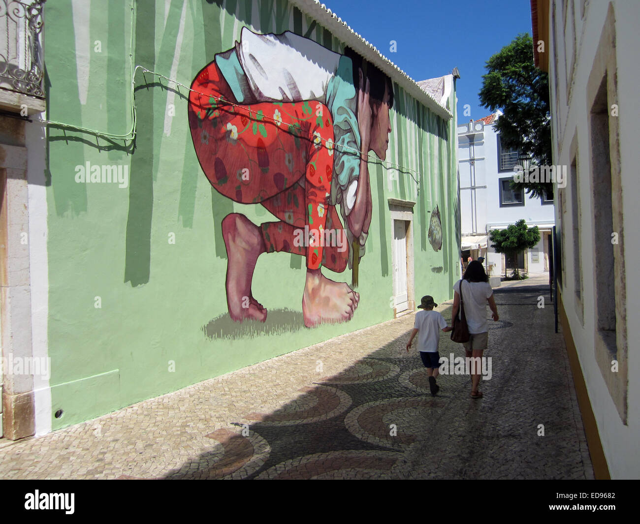 tourists walk past some lagos algarve portugal graffiti Stock Photo