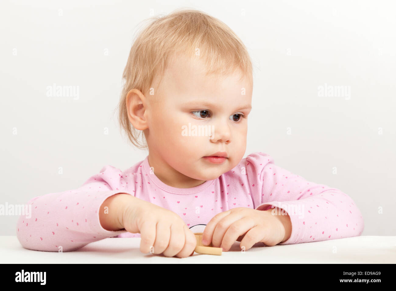 Caucasian baby girl in pink on white background, closeup studio portrait Stock Photo