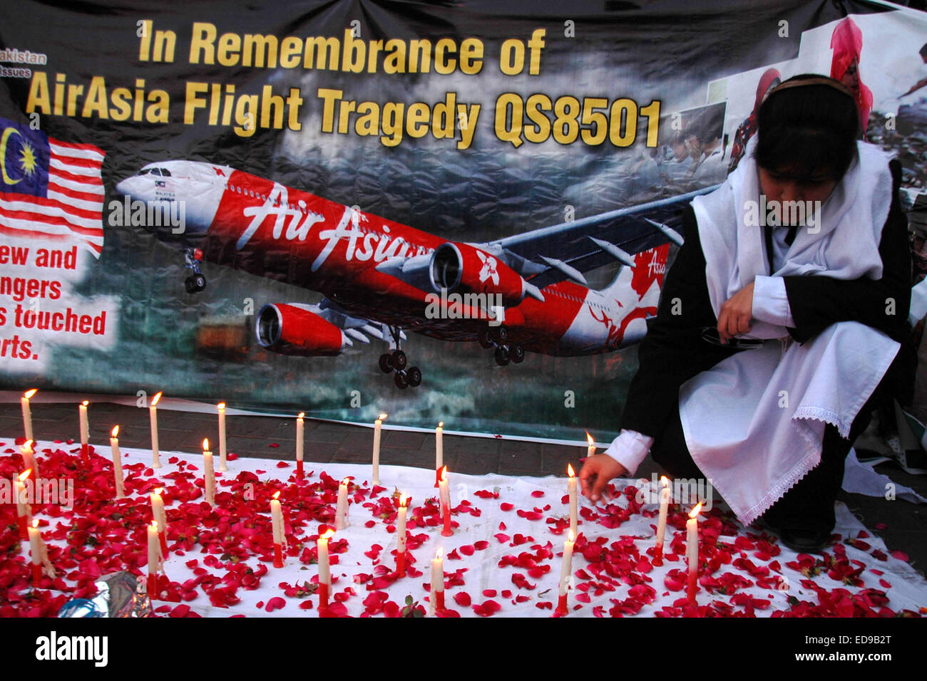 Lahore. 2nd Jan, 2015. A Pakistani woman lights candles during a remembrance vigil ceremony for the victims of AirAsia flight QZ8501 in eastern Pakistan's Lahore on Jan. 2, 2015. © Sajjad/Xinhua/Alamy Live News Stock Photo