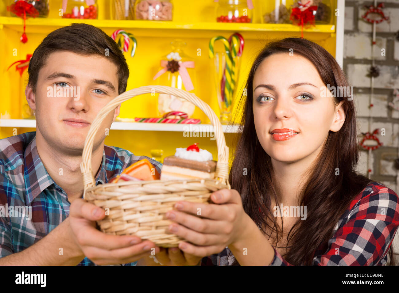 Smiling Couple Holding Up A Wicker Basket Of Replica Cookies And