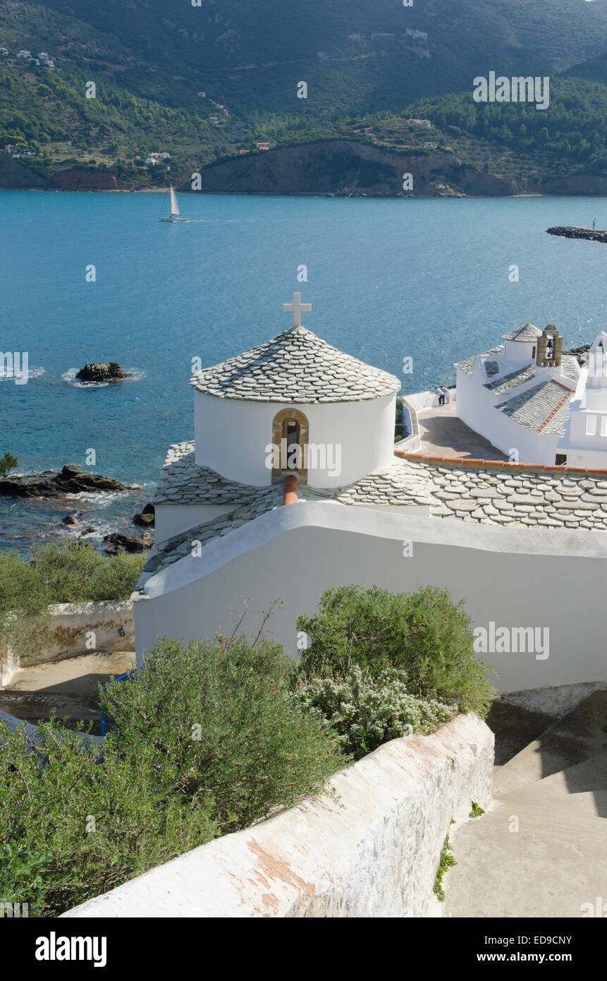 Churches and rooftops below the chora in Skopelos Town, Skopelos, Greek island. View out across the harbor and bay. October. Stock Photo