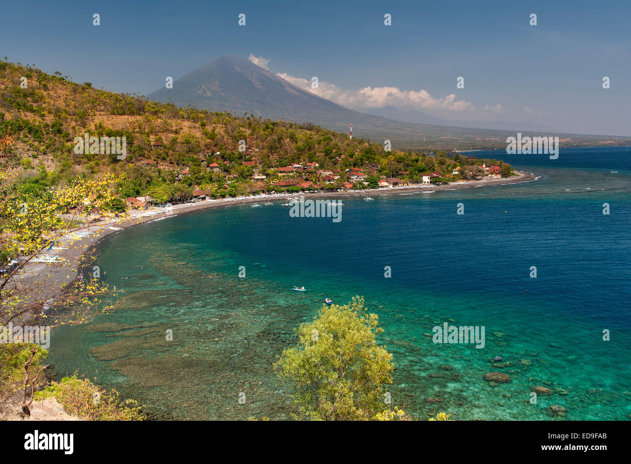 View of Mount Agung (3031m) and Jemulek beach & hamlet near Amed on the northeastern coast of Bali, Indonesia. Stock Photo