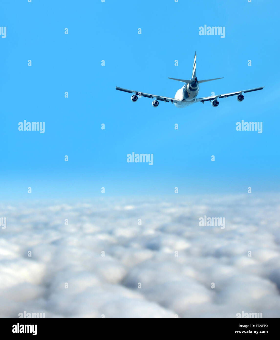 Heavy Boeing 747 jumbo jet airplane flying above the clouds Stock Photo