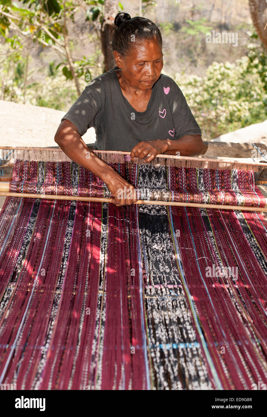 Indonesian woman weaving traditional sarongs on the roadside on the island of Flores in Indonesia. Stock Photo