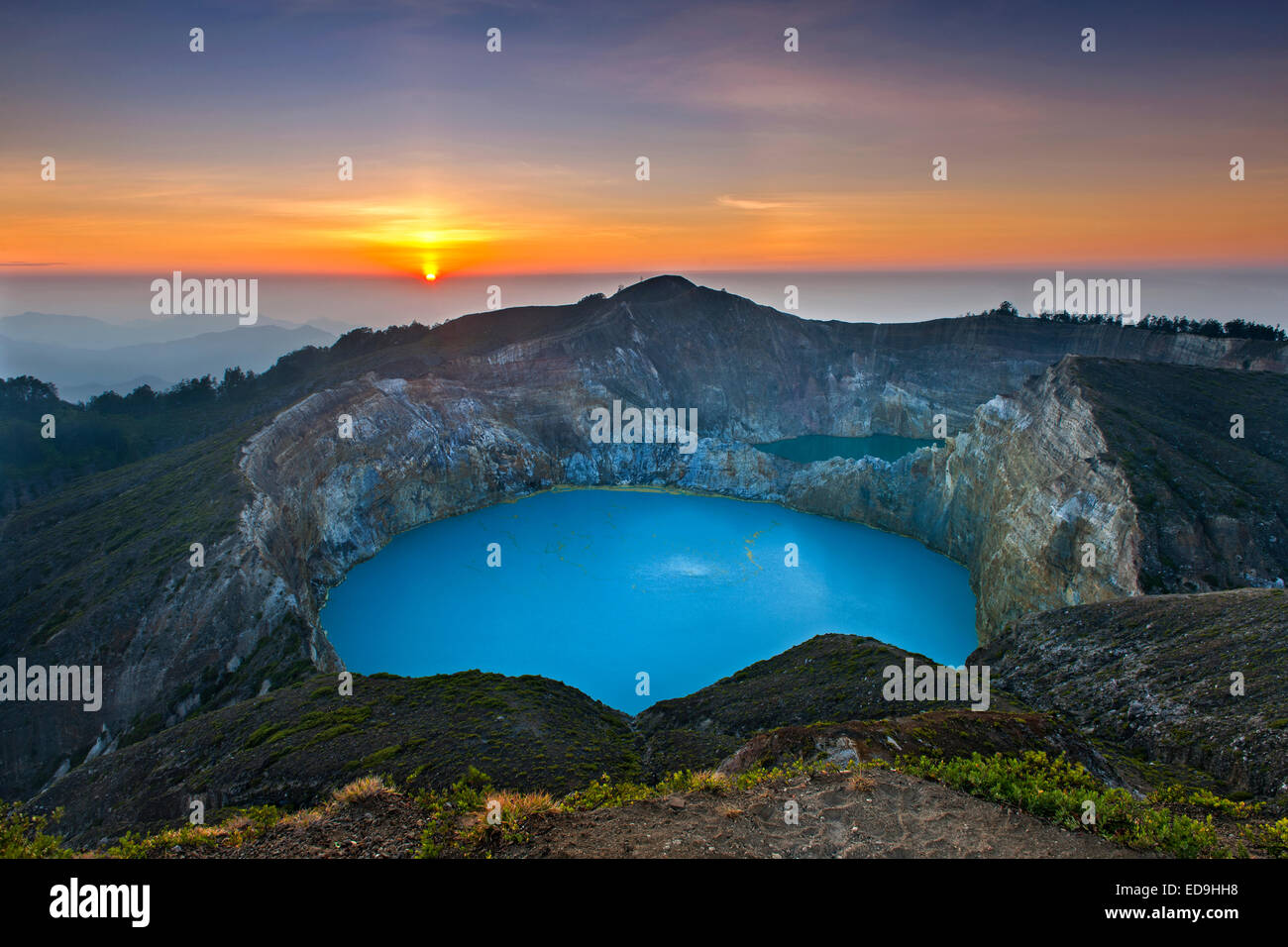 Sunrise over Tiwu Ko'o Fai Nuwa Muri, one of three crater lakes on the summit of Mount Kelimutu on Flores island, Indonesia. Stock Photo