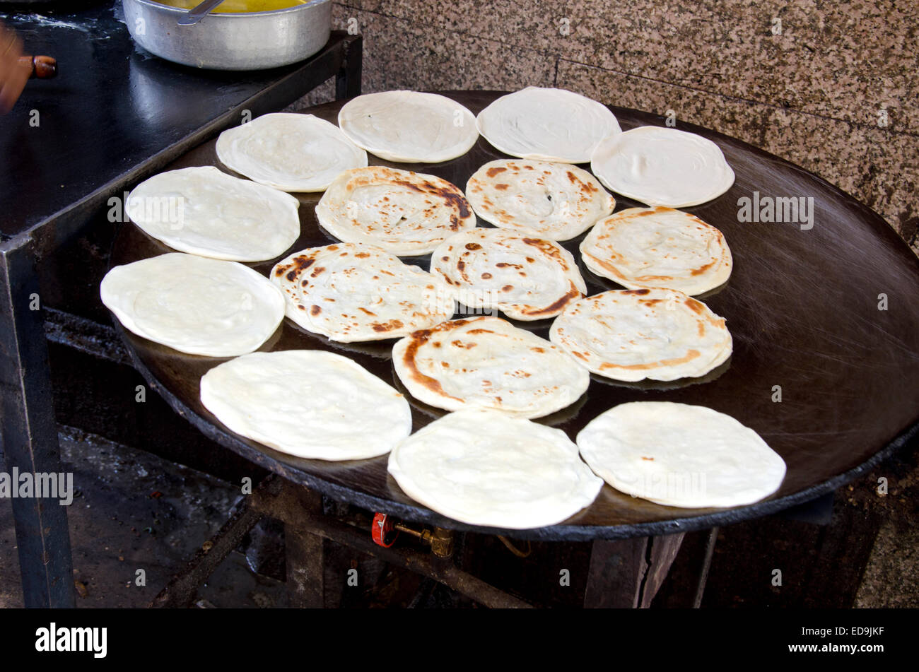 Indian Parrotha bread cooking on hotplate in marketplace Stock Photo