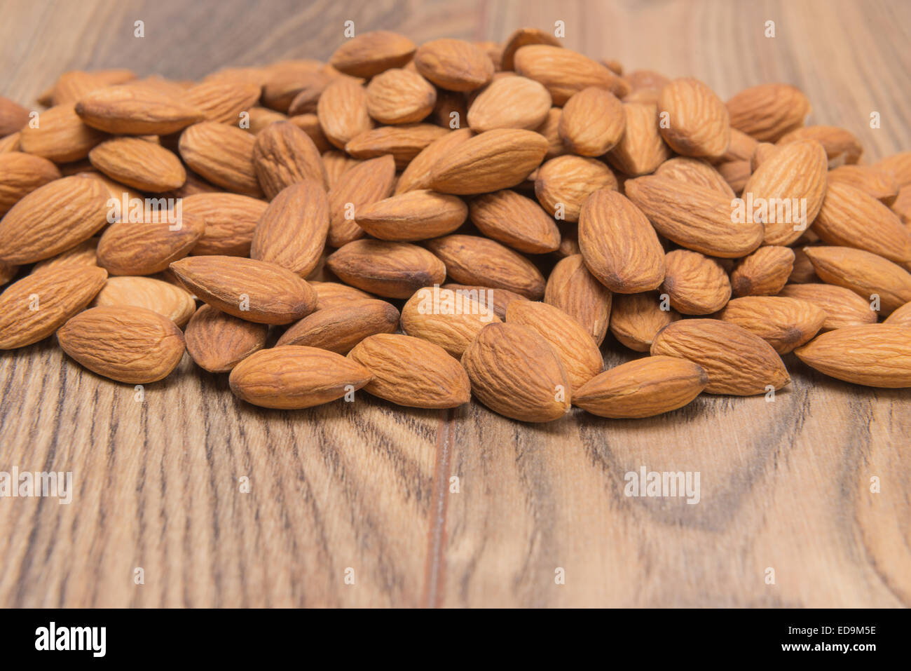 peeled almond nuts on a wooden background Stock Photo