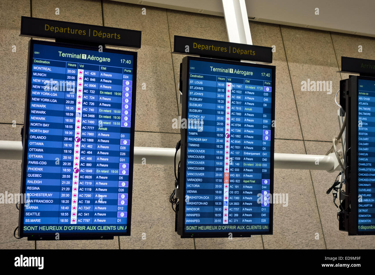 Screens with departure schedules at Pearson International Airport YYZ in Toronto, Ontario Canada. Written in French. Stock Photo
