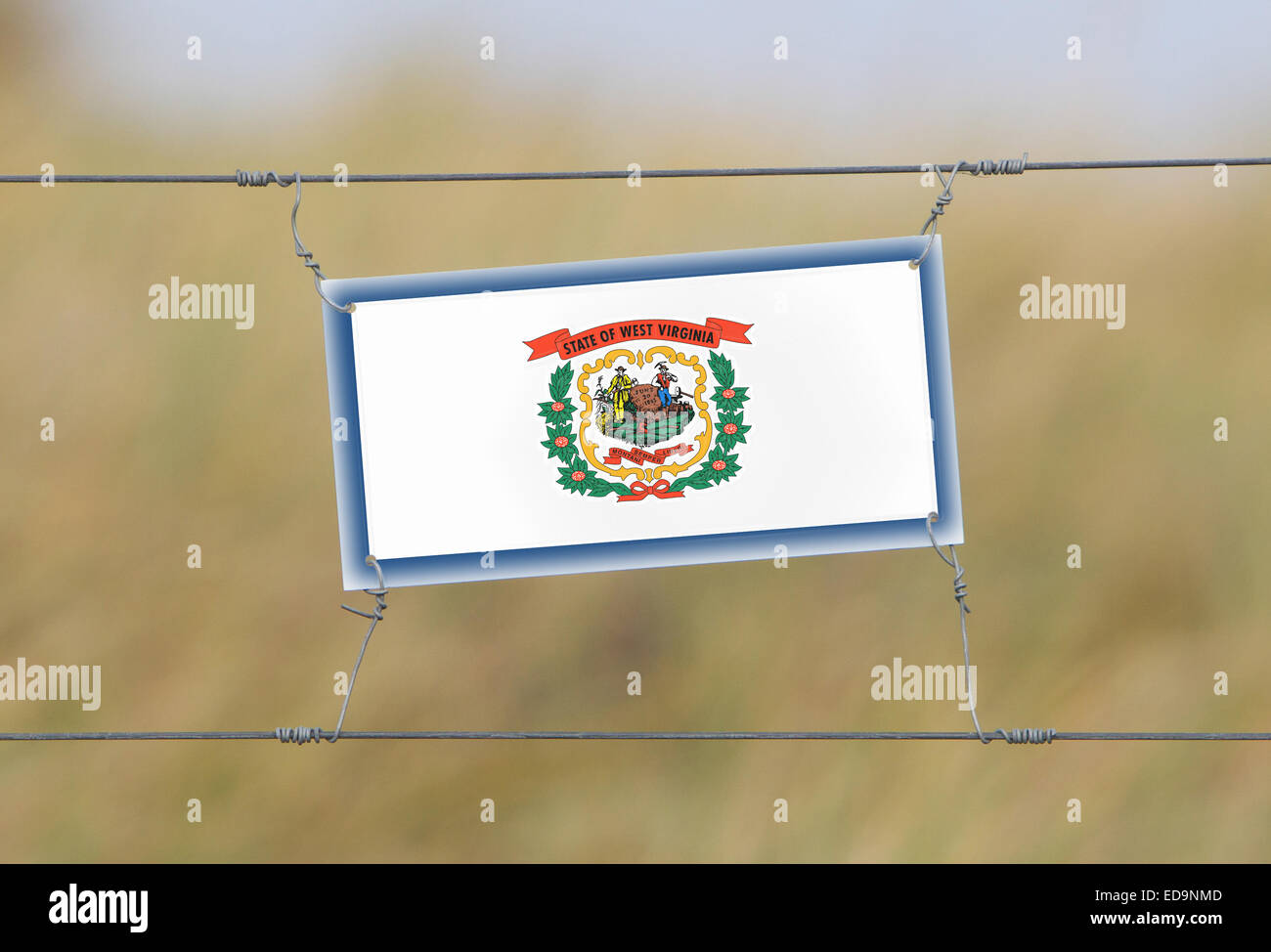 Border fence Old plastic sign with a flag West Virginia Stock Photo