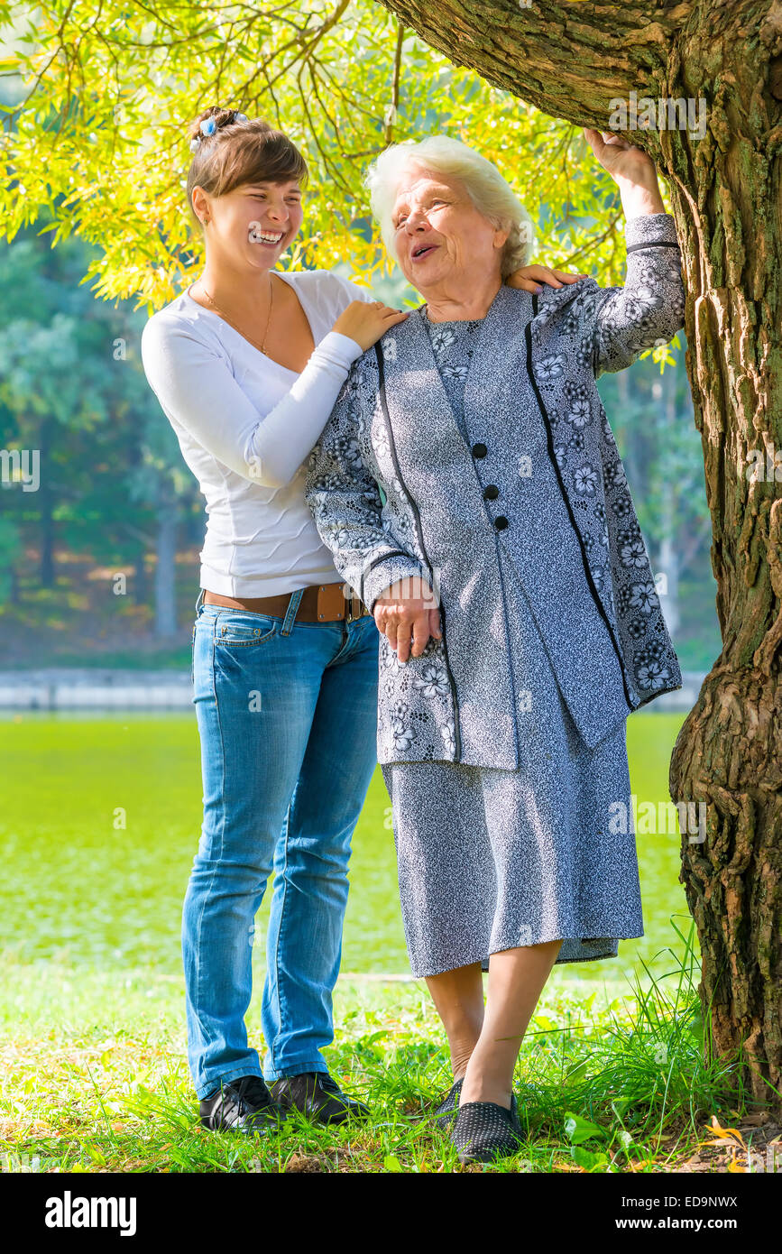 caring and loving granddaughter walking with her grandmother in the park Stock Photo