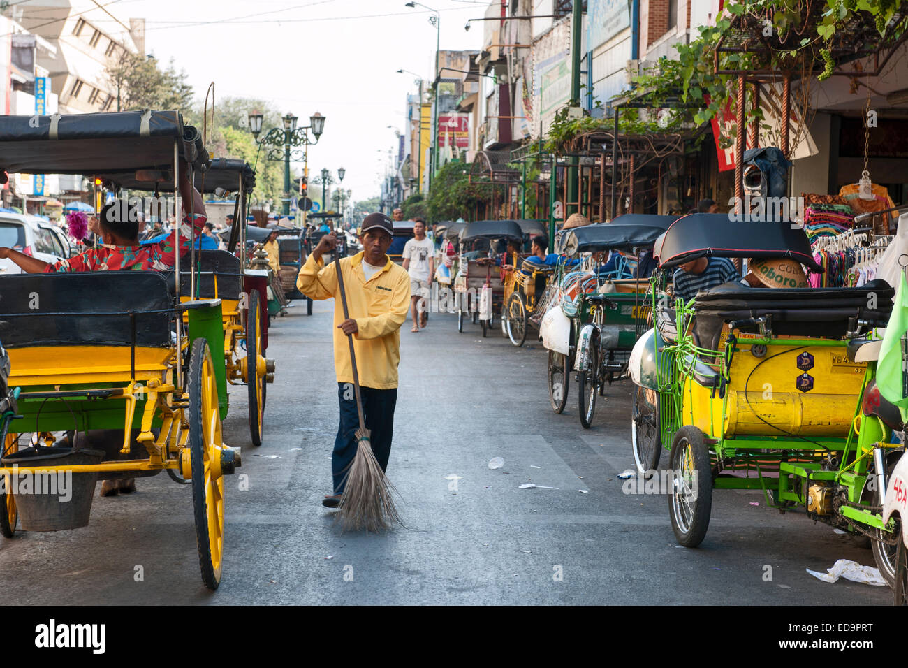 Street sweeper and horse carts on Jalan Malioboro, one of the main avenues in Yogyakarta, Java, Indonesia. Stock Photo