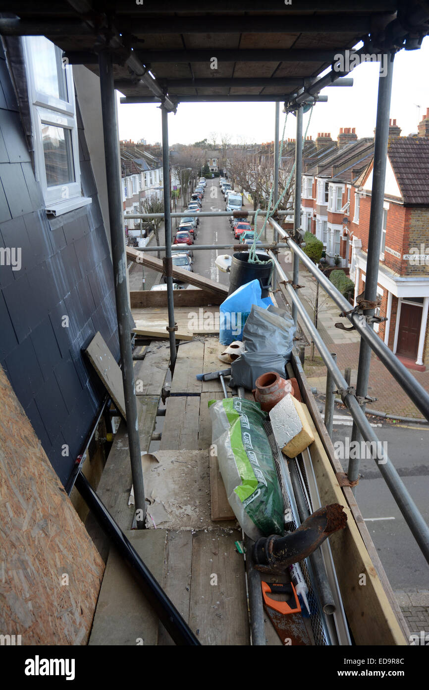 Outside view of a nearly completed loft conversion in southwest London showing scaffolding and builder's tools Stock Photo