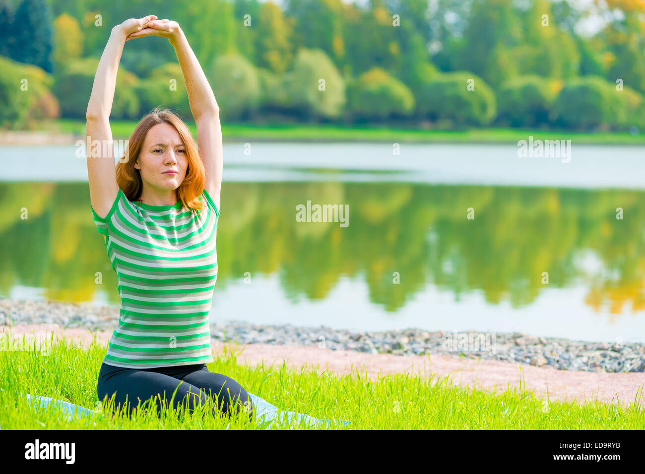girl performs stretching exercises back muscles in nature Stock Photo ...