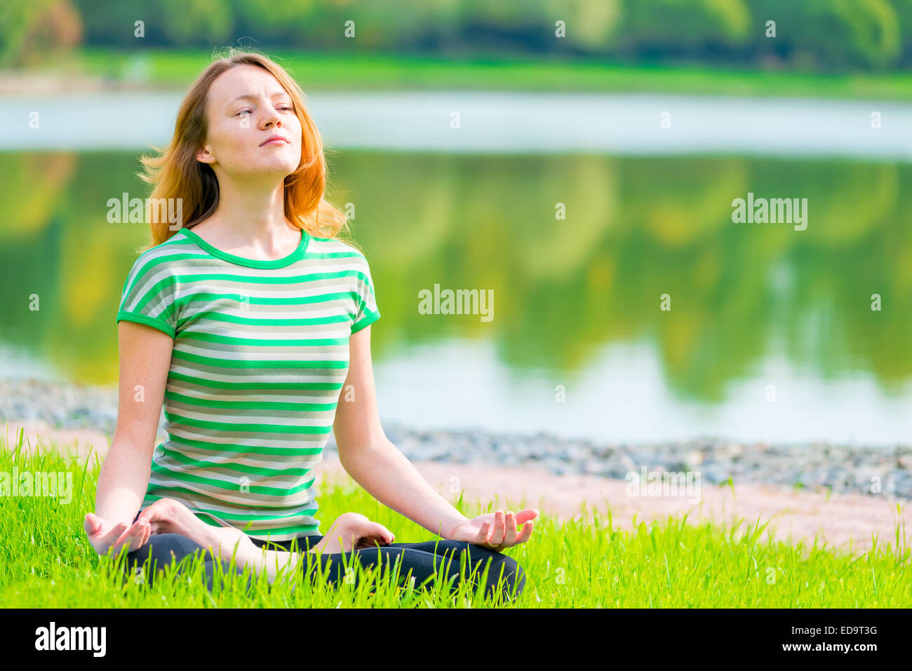 focused athlete relaxes in a lotus position on the nature Stock Photo