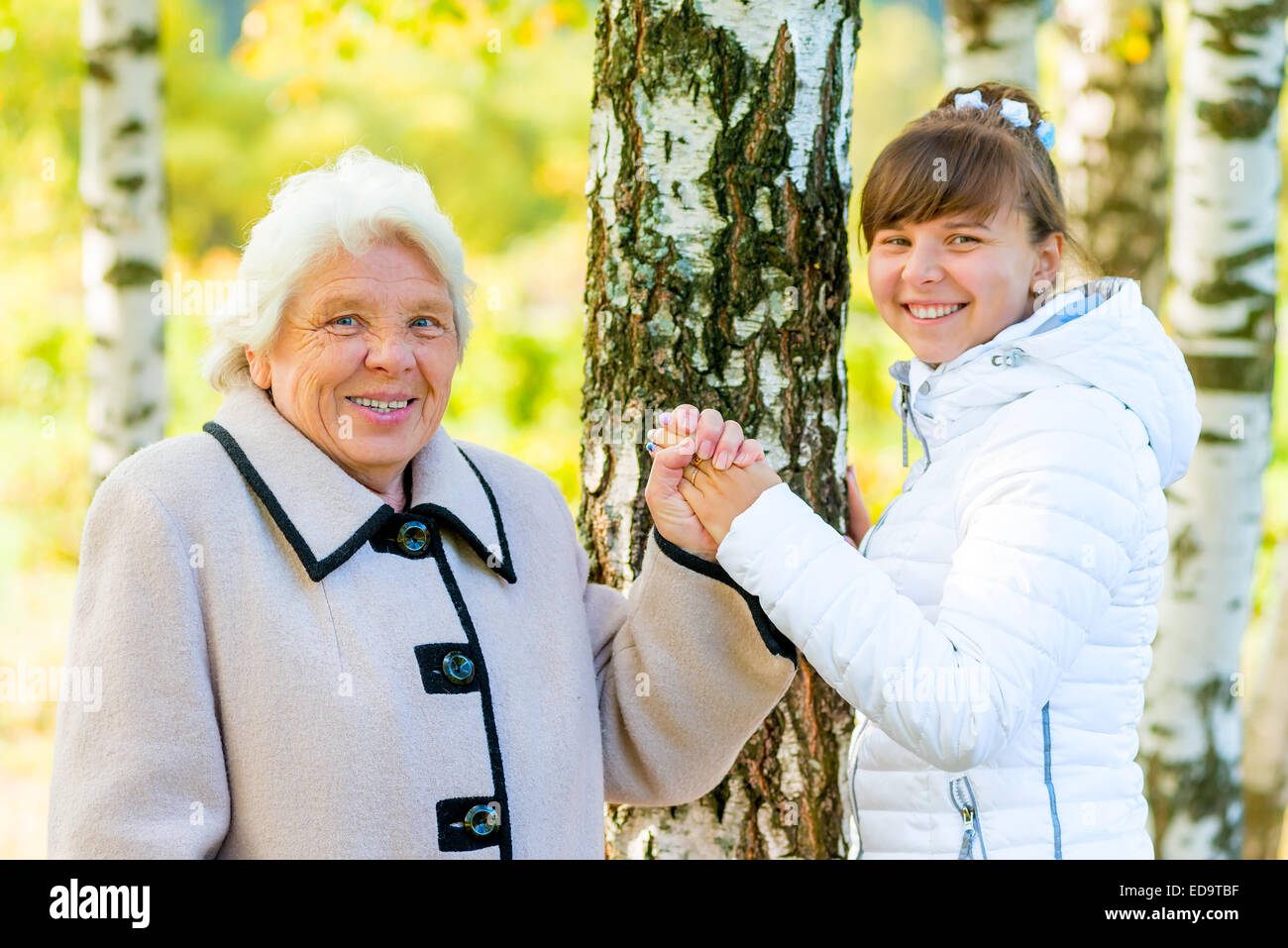 grandmother and granddaughter walking in the autumn park Stock Photo
