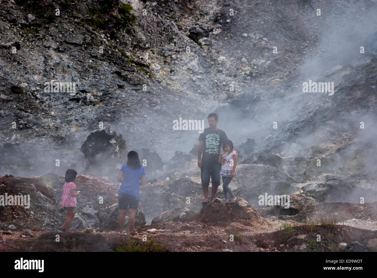 Visitors are having recreational time on fumarole field at Bukit Kasih, a popular tourist destination in Minahasa, North Sulawesi, Indonesia. Stock Photo