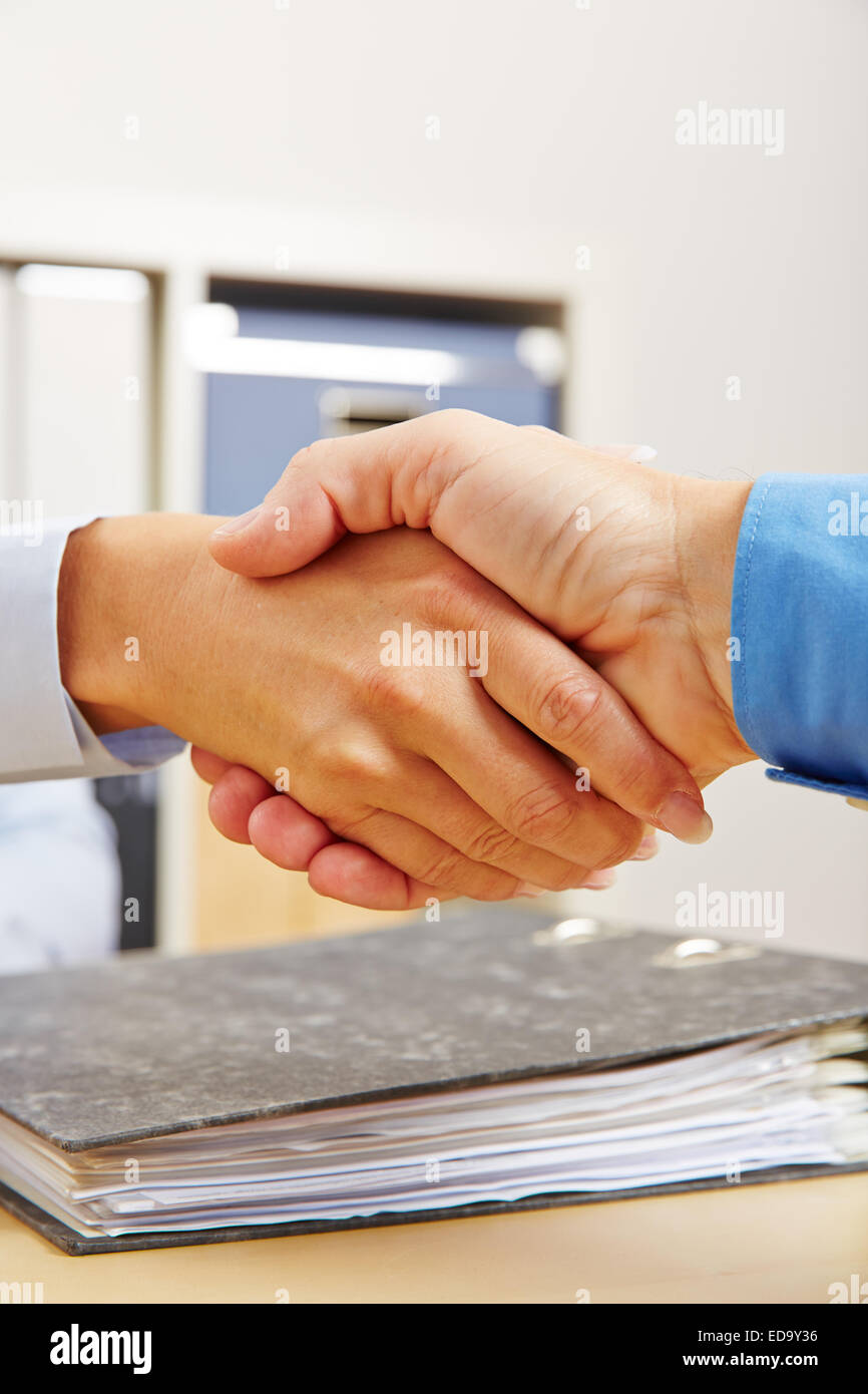 Business people shake hands in office after contract deal Stock Photo