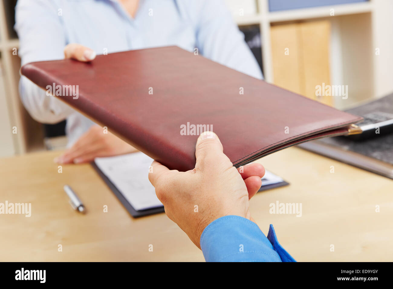 Hands of woman giving application portfolio to HR man in office Stock Photo
