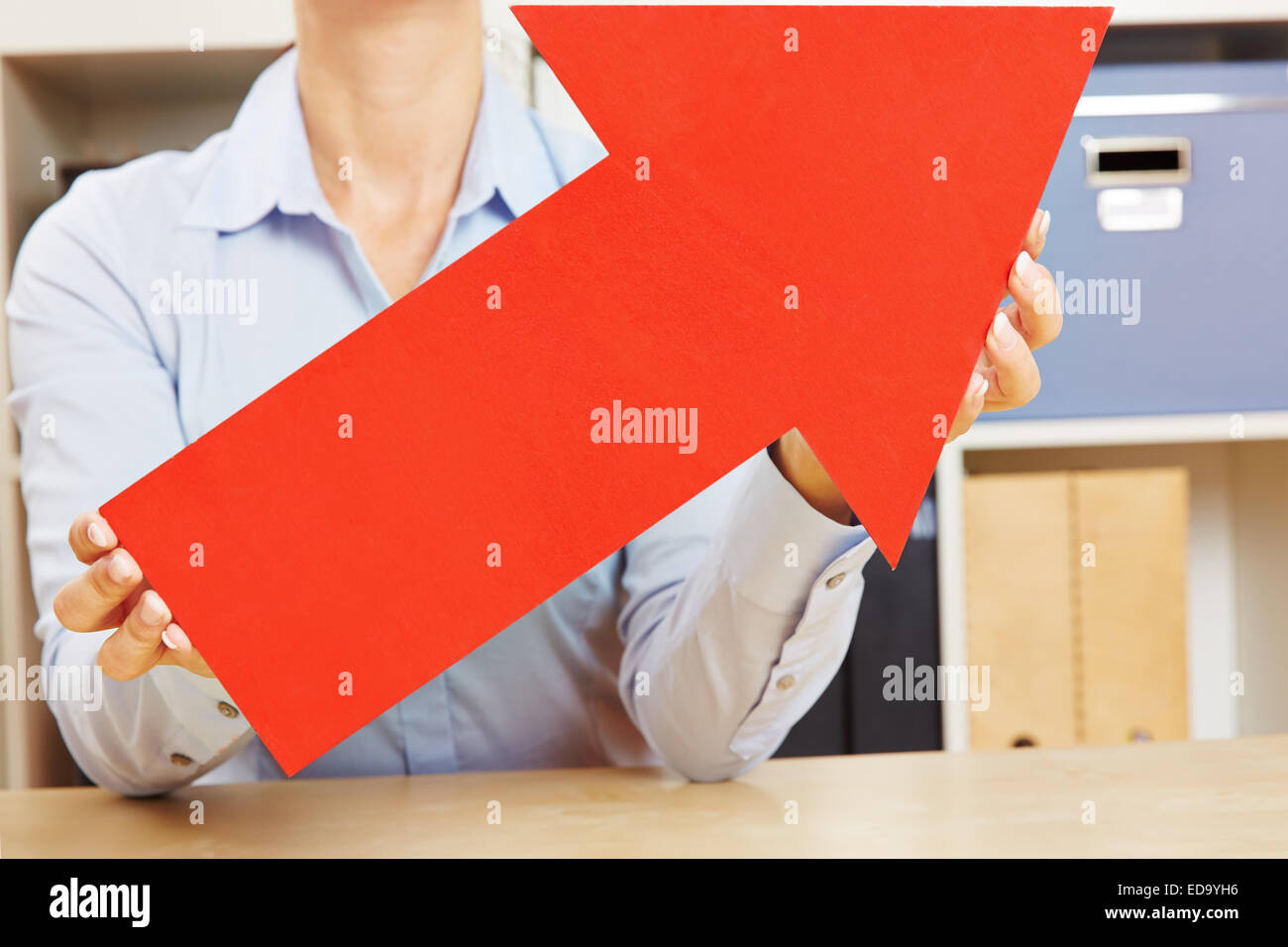 Big red arrow pointing up being held by female hands Stock Photo - Alamy