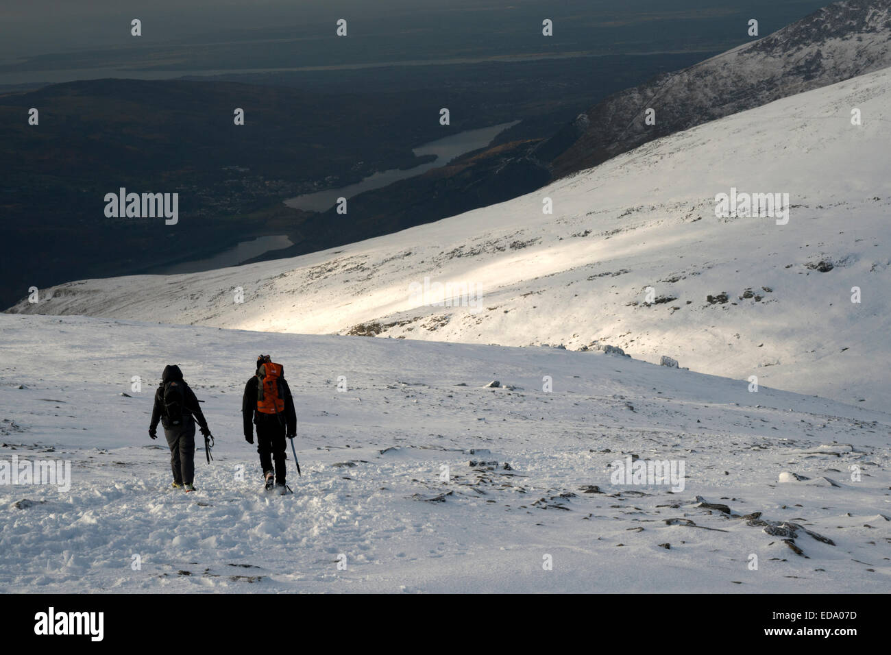 Couple descending Glyder Fawr in snowy conditions.  Glyder Fawr, Snowdonia National Park, Wales, UK Stock Photo