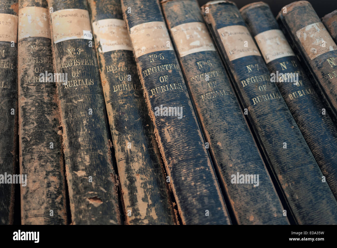 row of registry of burials old records in leather bound books volumes journals covering last century 1800's and world war one 1 Stock Photo